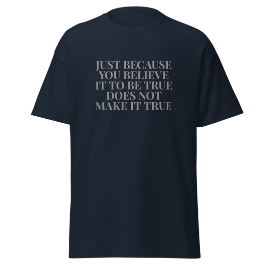 "Just because you believe it to be true does not make it true" printed on a navy unisex classic tee laying on a flat surface