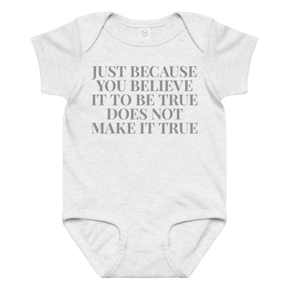 "Just because you believe it to be true does not make it true" printed on a ash baby jersey bodysuit laying on a flat surface amongst other clothes