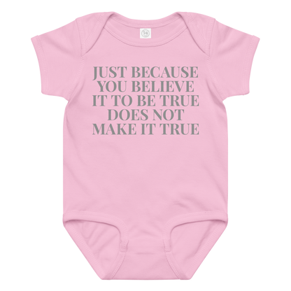 "Just because you believe it to be true does not make it true" printed on a pink baby jersey bodysuit laying on a flat surface amongst other clothes