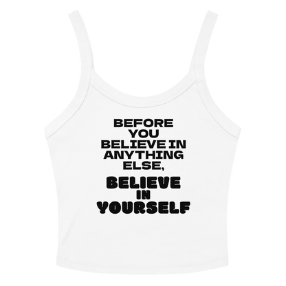 "Before you believe in anything else, believe in yourself" printed on a solid white blend women's micro-rib tanktop laying on a flat surface amongst sunglasses and shorts