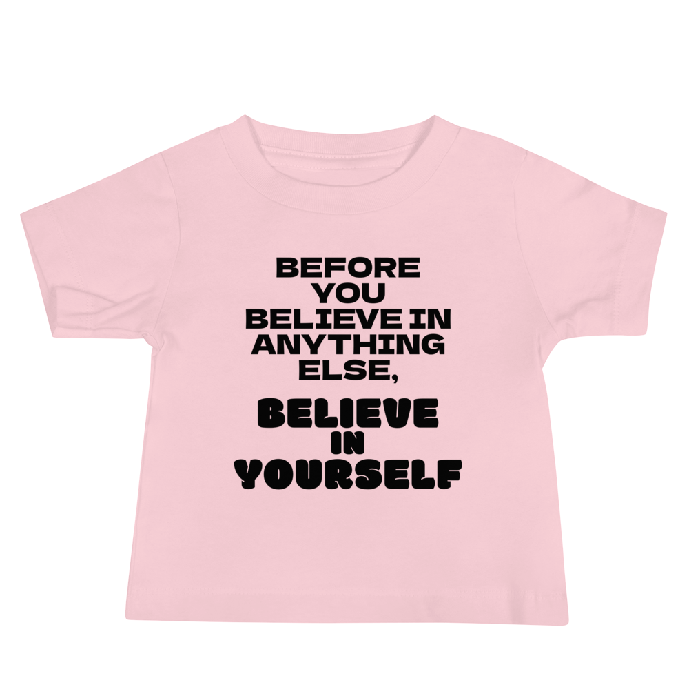 "Before you believe in anything else, believe in yourself" printed on a pink baby jersey short sleeve tee laying on a flat surface