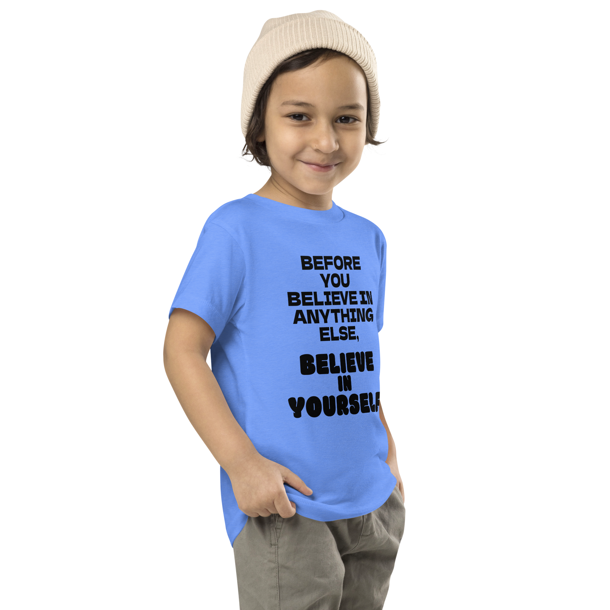 "Before you believe in anything else, believe in yourself" printed on a heather columbia blue toddler short sleeve tee worn by a male who is also wearing a knit cap