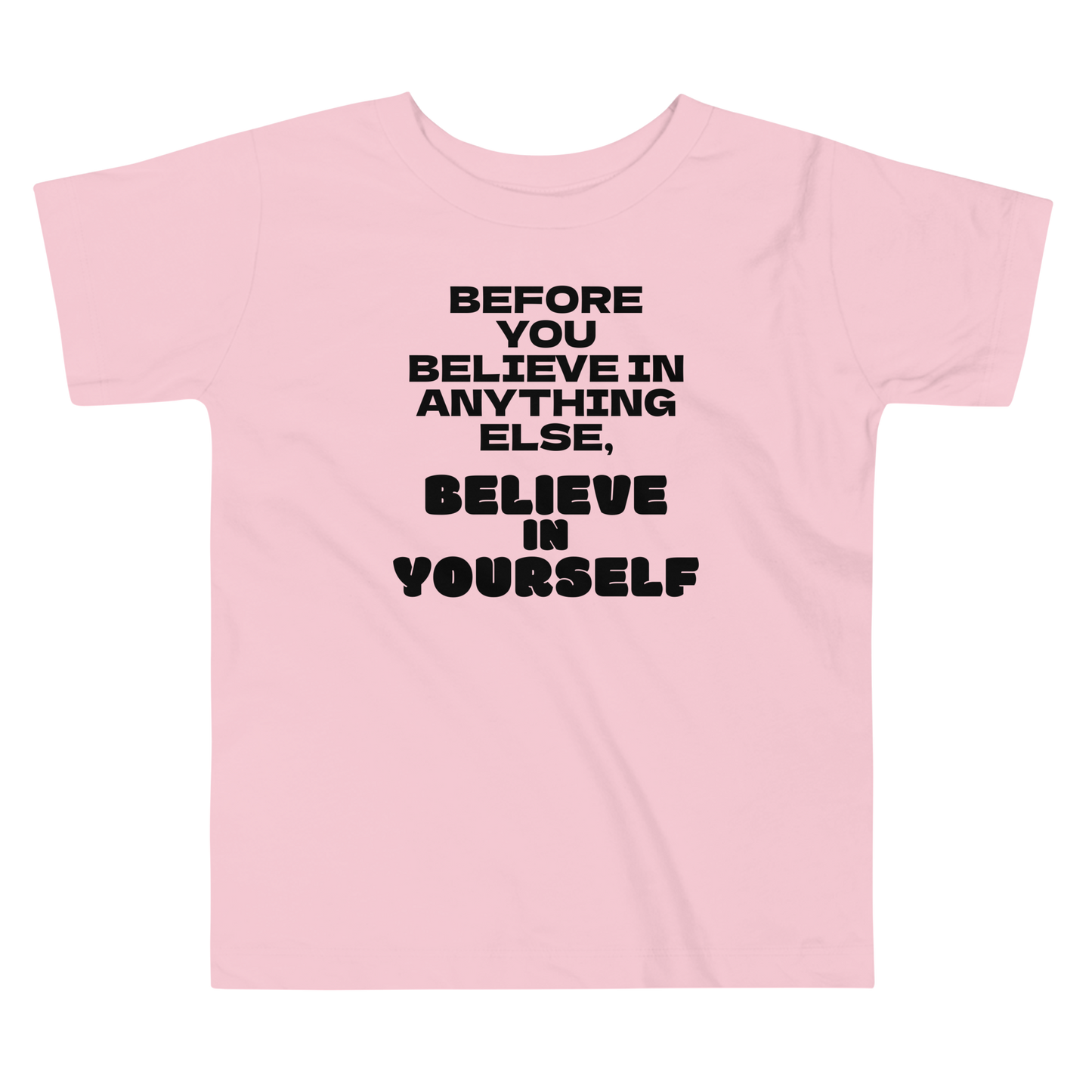 "Before you believe in anything else, believe in yourself" printed on a pink toddler short sleeve tee laying on a flat surface