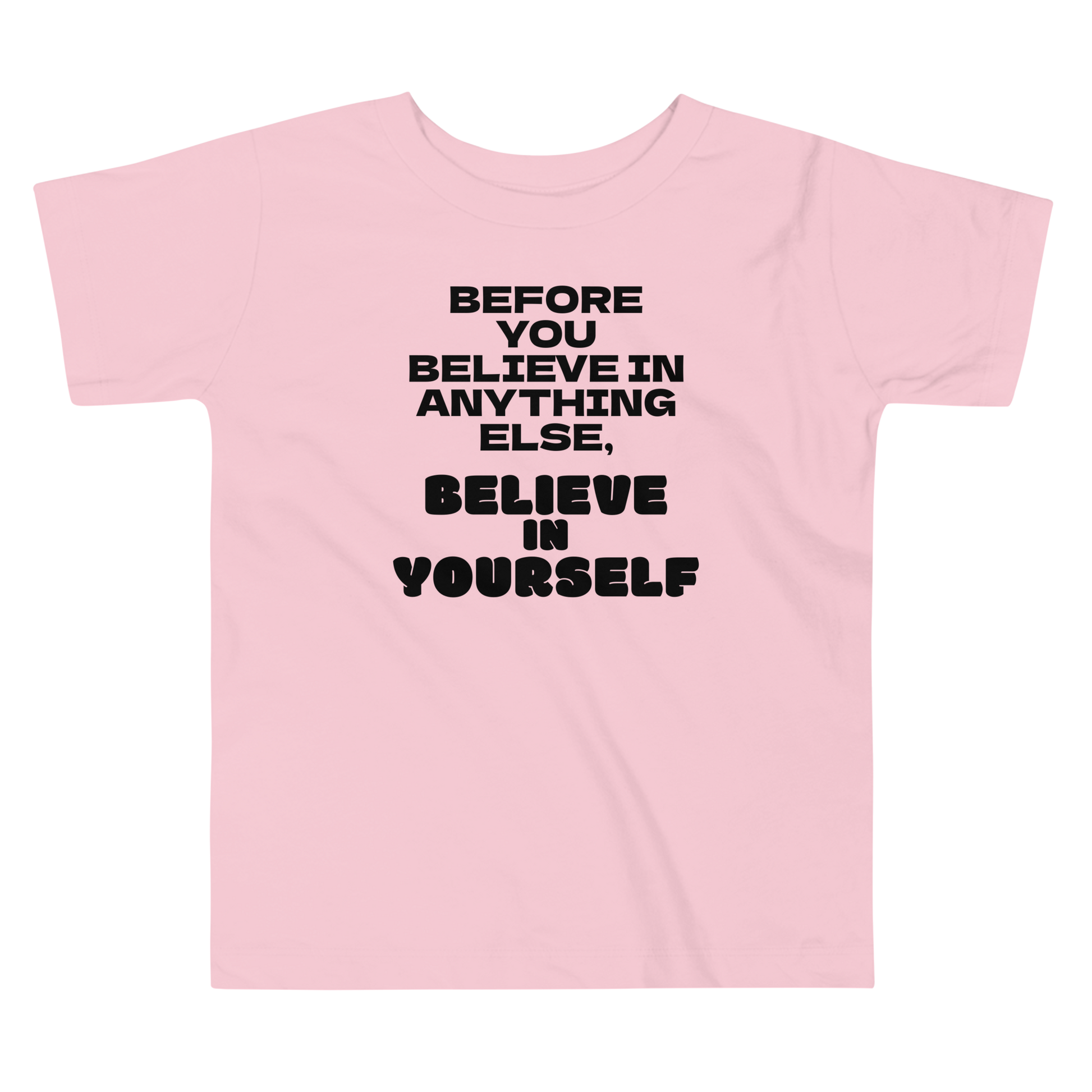 "Before you believe in anything else, believe in yourself" printed on a pink toddler short sleeve tee laying on a flat surface