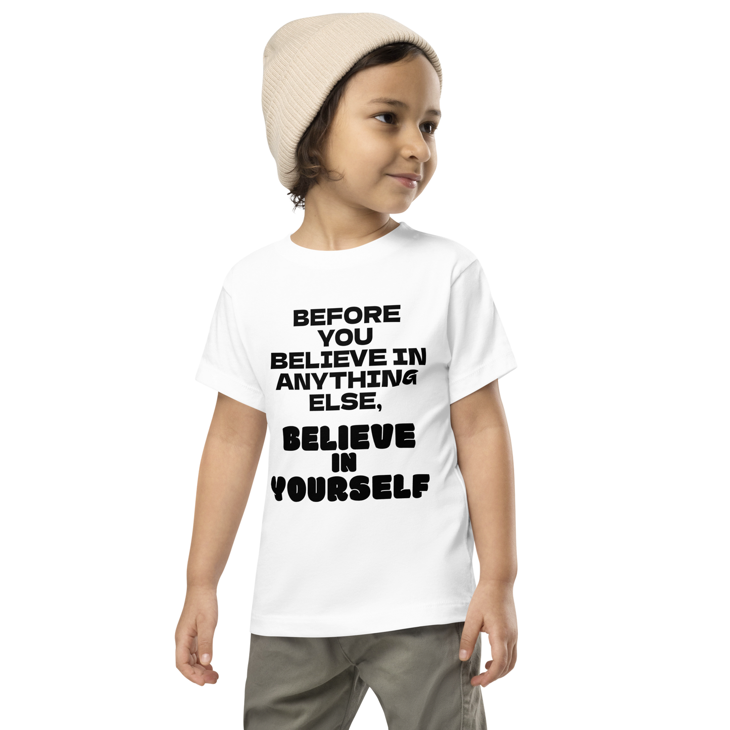 "Before you believe in anything else, believe in yourself" printed on a white toddler short sleeve tee worn by a male wearing a cap