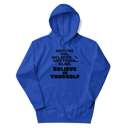 "Before you believe in anything else, believe in yourself" printed on a team royal unisex hoodie laying on a flat surface with the hood up