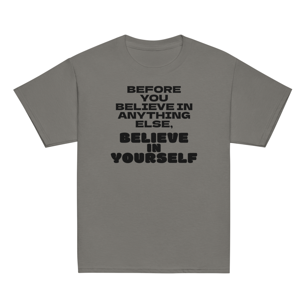 "Before you believe in anything else, believe in yourself" printed on a charcoal youth classic tee laying on a flat surface