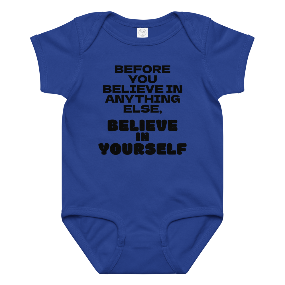"Before you believe in anything else, believe in yourself" printed on a royal baby jersey bodysuit laying on a flat surface amongst other clothes