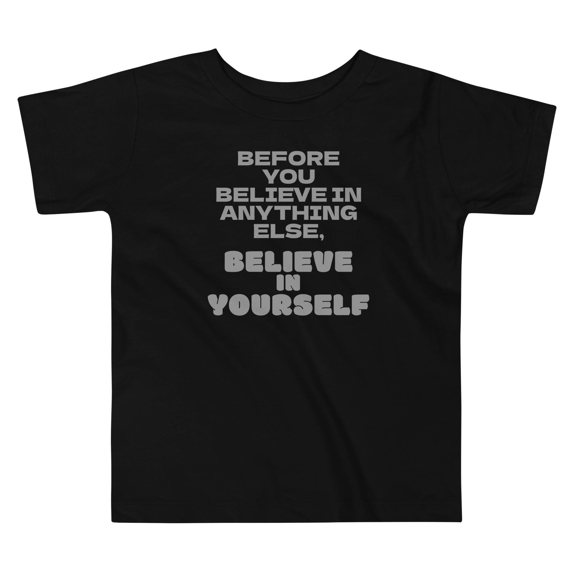 "Before you believe in anything else, believe in yourself" printed on a black toddler short sleeve tee laying on a flat surface