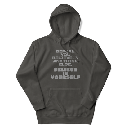 "Before you believe in anything else, believe in yourself" printed on a vintage black unisex hoodie laying on a flat surface with the hood up
