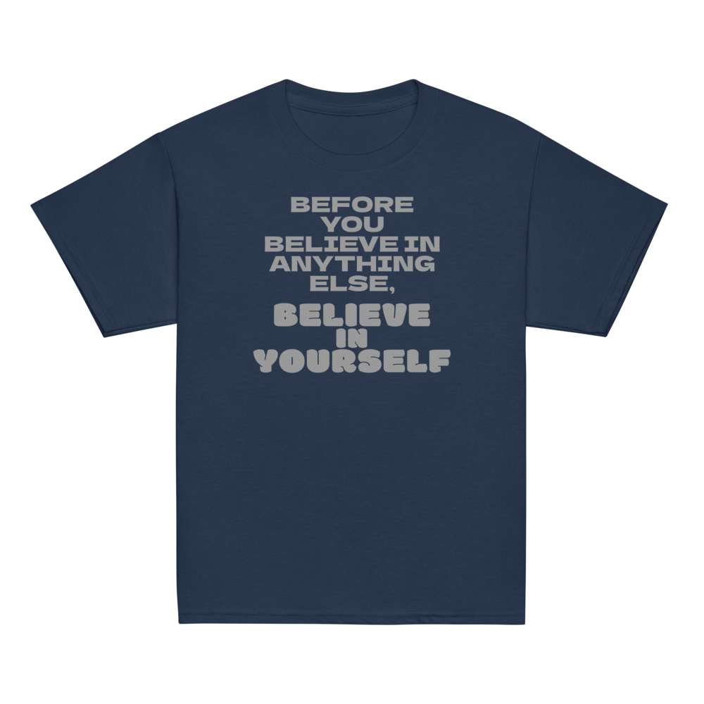 "Before you believe in anything else, believe in yourself" printed on a navy youth classic tee laying on a flat surface