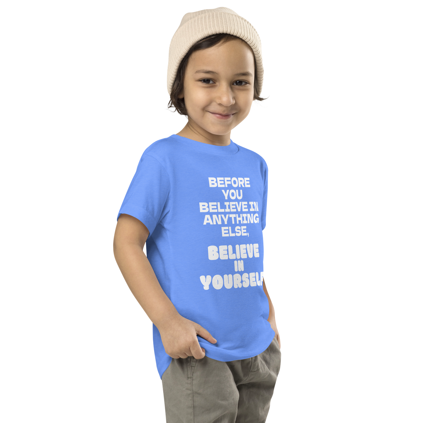 "Before you believe in anything else, believe in yourself" printed on a heather columbia blue toddler short sleeve tee worn by a male who is also wearing a knit cap