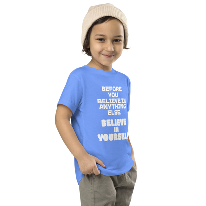 "Before you believe in anything else, believe in yourself" printed on a heather columbia blue toddler short sleeve tee worn by a male who is also wearing a knit cap