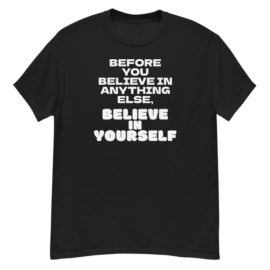 "Before you believe in anything else, believe in yourself" printed on a black unisex classic tee laying on a flat surface