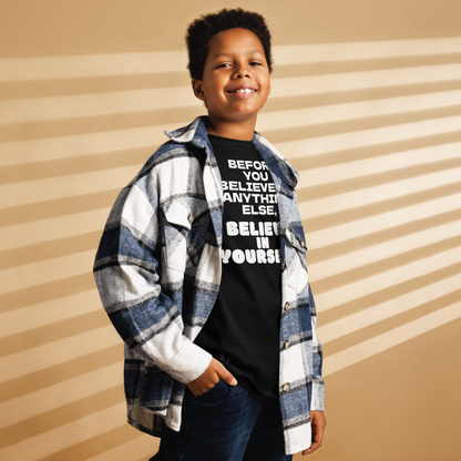 "Before you believe in anything else, believe in yourself" printed on a black youth classic tee worn by a male also wearing a jacket