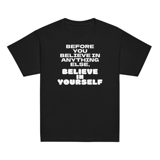 "Before you believe in anything else, believe in yourself" printed on a black youth classic tee laying on a flat surface