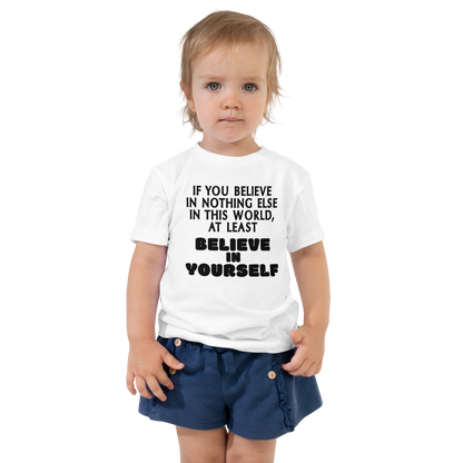 "If you believe in nothing else in this world, at least believe in yourself" printed on a white toddler short sleeve tee worn by a female