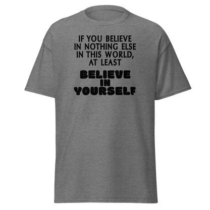 "If you believe in nothing else in this world, at least believe in yourself" printed on a graphite heather unisex classic tee laying on a flat surface