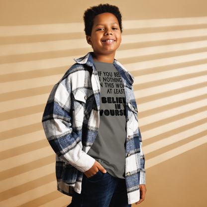 "If you believe in nothing else in this world, at least believe in yourself" printed on a charcoal youth classic tee worn by a male also wearing a jacket
