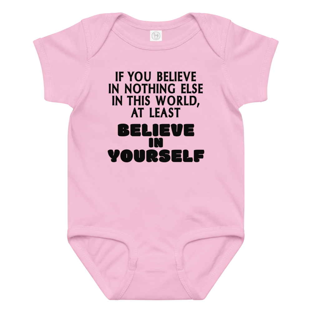 "If you believe in nothing else in this world, at least believe in yourself" printed on a pink baby jersey bodysuit laying on a flat surface amongst other clothes