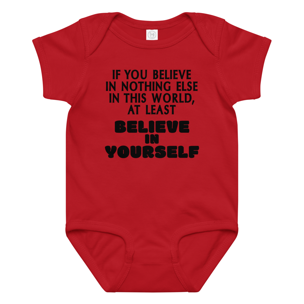 "If you believe in nothing else in this world, at least believe in yourself" printed on a red baby jersey bodysuit laying on a flat surface amongst other clothes