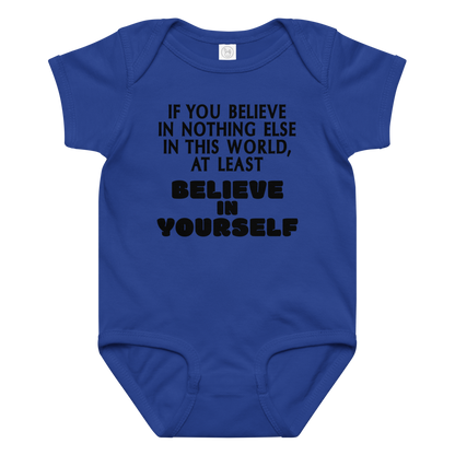 "If you believe in nothing else in this world, at least believe in yourself" printed on a royal baby jersey bodysuit laying on a flat surface amongst other clothes