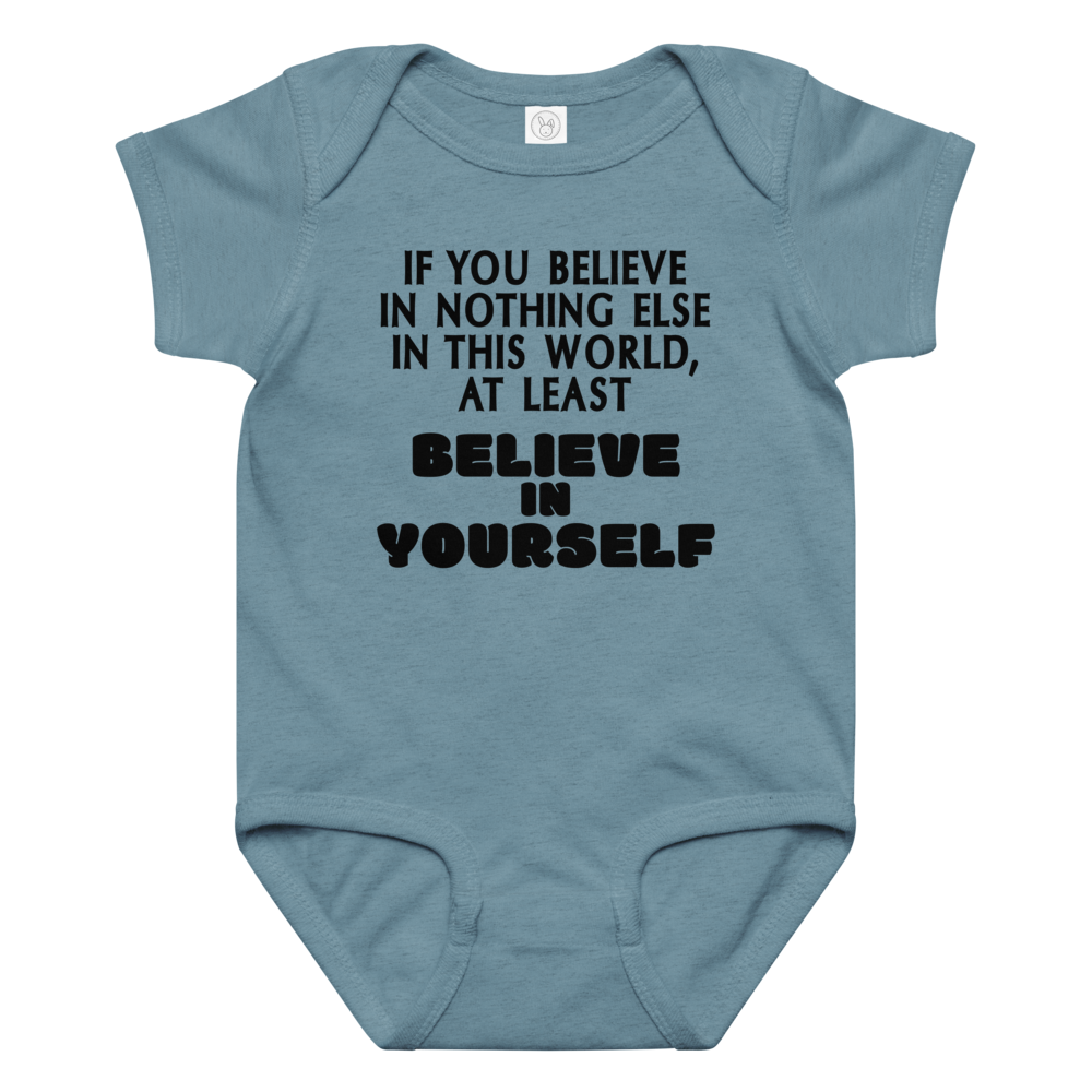 "If you believe in nothing else in this world, at least believe in yourself" printed on a vintage indigo baby jersey bodysuit laying on a flat surface amongst other clothes