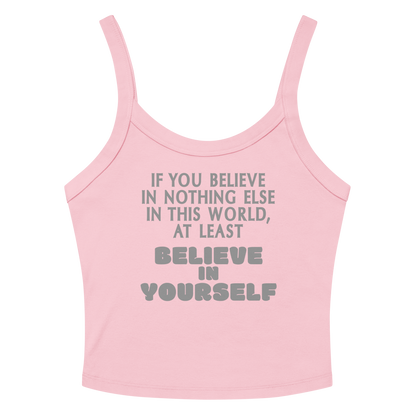 "If you believe in nothing else in this world, at least believe in yourself" printed on a solid pink blend women's micro-rib tanktop laying on a flat surface amongst sunglasses and shorts