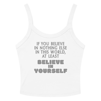 "If you believe in nothing else in this world, at least believe in yourself" printed on a solid white blend women's micro-rib tanktop laying on a flat surface amongst sunglasses and shorts