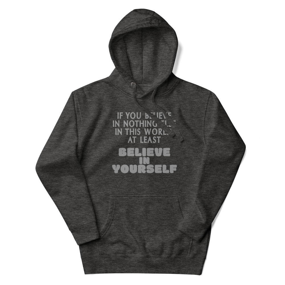 "If you believe in nothing else in this world, at least believe in yourself" printed on a charcoal heather unisex hoodie laying on a flat surface with the hood up