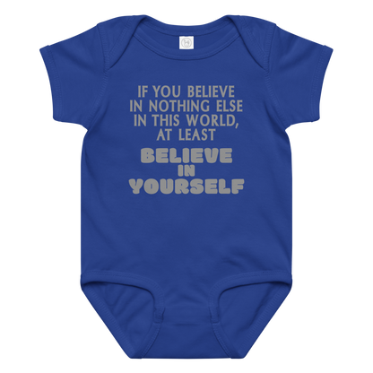 "If you believe in nothing else in this world, at least believe in yourself" printed on a royal baby jersey bodysuit laying on a flat surface amongst other clothes