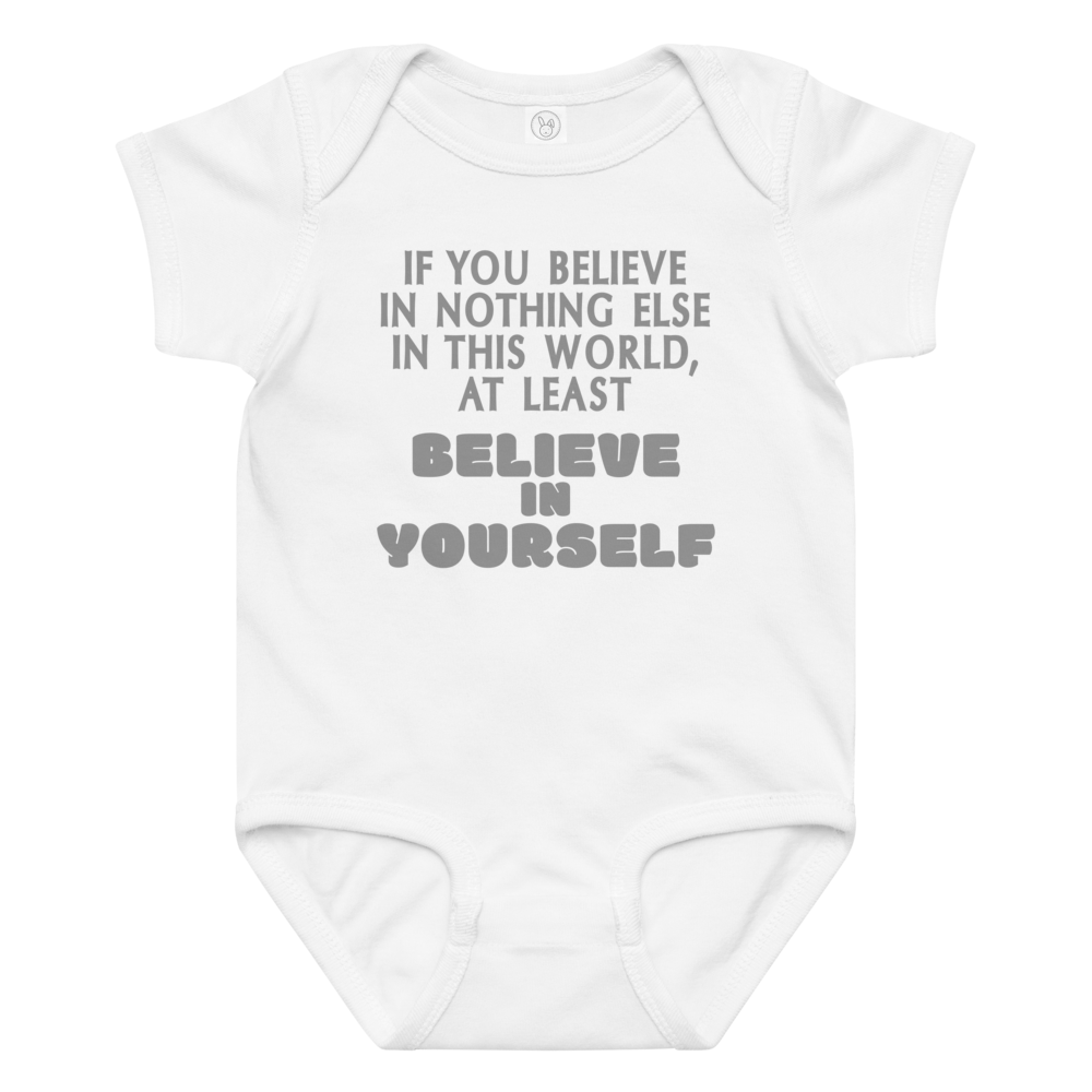 "If you believe in nothing else in this world, at least believe in yourself" printed on a white baby jersey bodysuit laying on a flat surface amongst other clothes