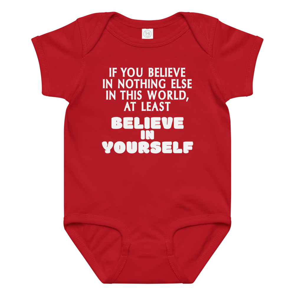 "If you believe in nothing else in this world, at least believe in yourself" printed on a red baby jersey bodysuit laying on a flat surface amongst other clothes
