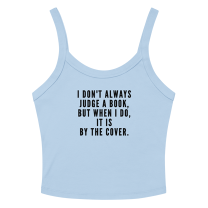 "I Don't always Judge a Book, but when I do, it's by the cover." printed on a solid baby blue blend women's micro-rib tanktop laying on a flat surface amongst sunglasses and shorts
