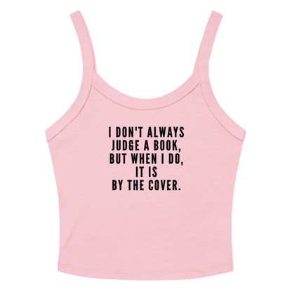 "I Don't always Judge a Book, but when I do, it's by the cover." printed on a solid pink blend women's micro-rib tanktop laying on a flat surface amongst sunglasses and shorts