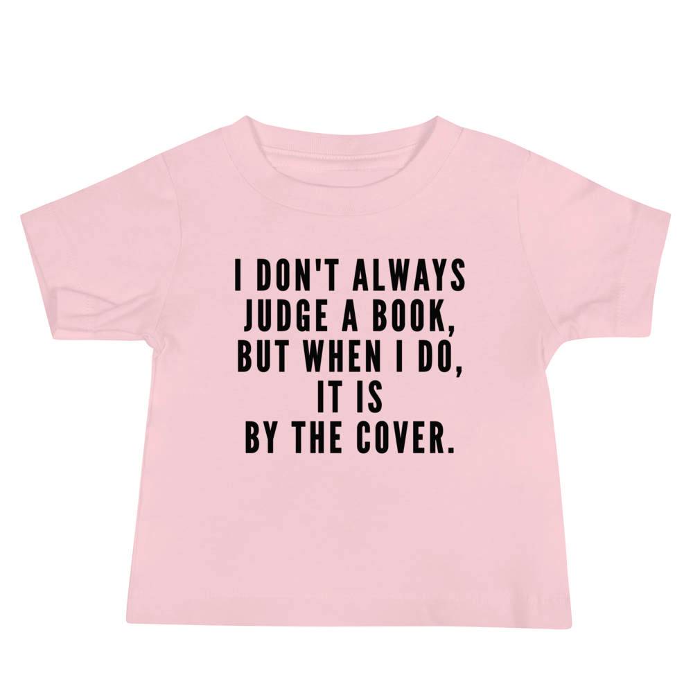 "I Don't always Judge a Book, but when I do, it's by the cover." printed on a pink baby jersey short sleeve tee laying on a flat surface