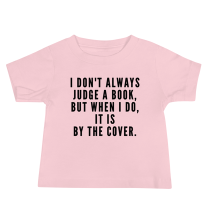 "I Don't always Judge a Book, but when I do, it's by the cover." printed on a pink baby jersey short sleeve tee laying on a flat surface