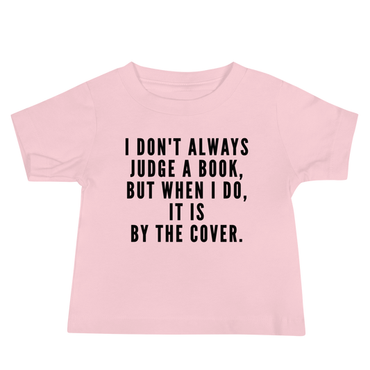 "I Don't always Judge a Book, but when I do, it's by the cover." printed on a pink baby jersey short sleeve tee laying on a flat surface
