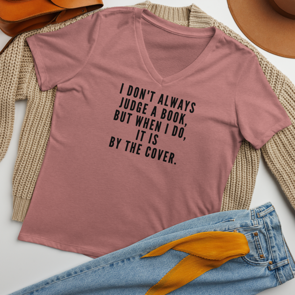 "I Don't always Judge a Book, but when I do, it's by the cover." printed on a heather mauve women's relaxed v-neck t-shirt laying on a flat surface amongst other clothes