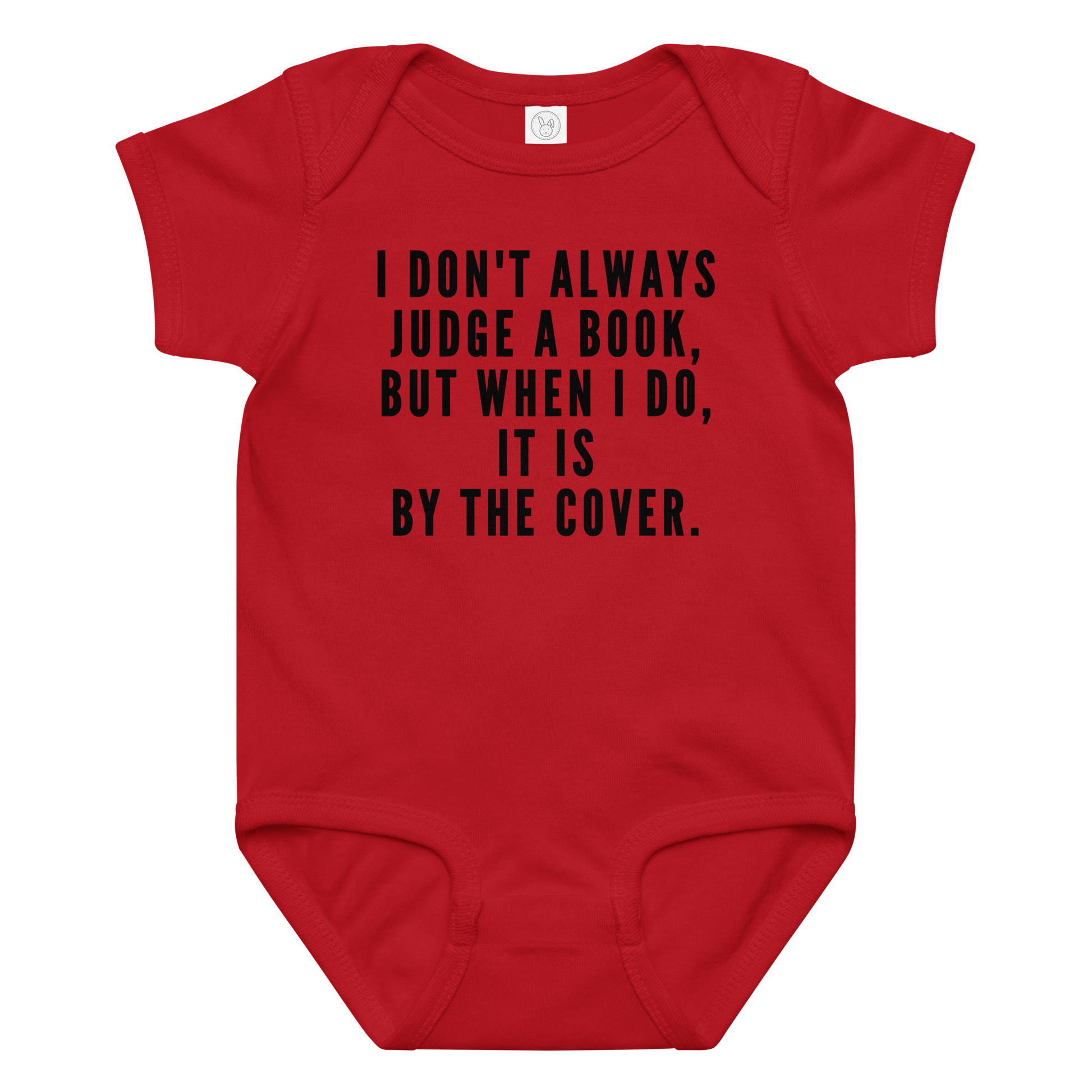 "I Don't always Judge a Book, but when I do, it's by the cover." printed on a red baby jersey bodysuit laying on a flat surface amongst other clothes