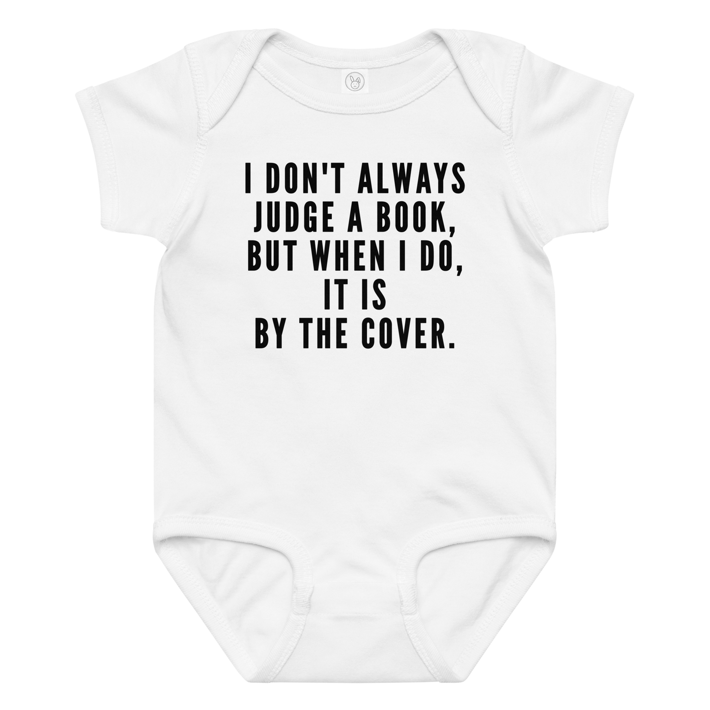"I Don't always Judge a Book, but when I do, it's by the cover." printed on a white baby jersey bodysuit laying on a flat surface amongst other clothes