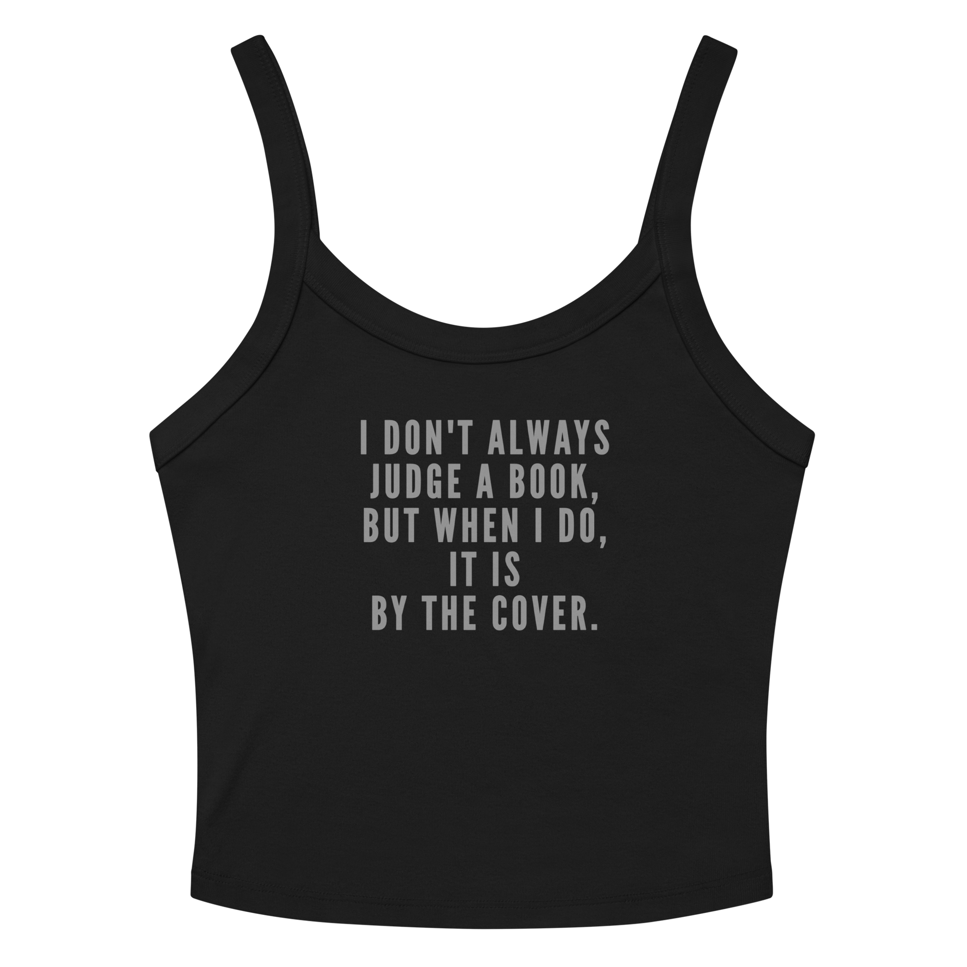 "I Don't always Judge a Book, but when I do, it's by the cover." printed on a solid black blend women's micro-rib tanktop laying on a flat surface amongst sunglasses and shorts