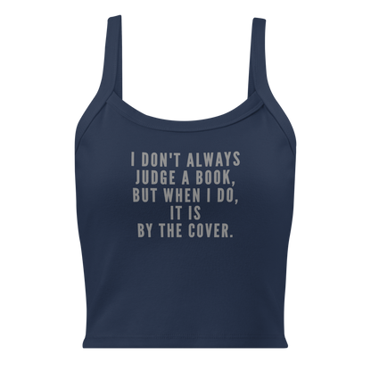 "I Don't always Judge a Book, but when I do, it's by the cover." printed on a solid navy blend women's micro-rib tanktop laying on a flat surface