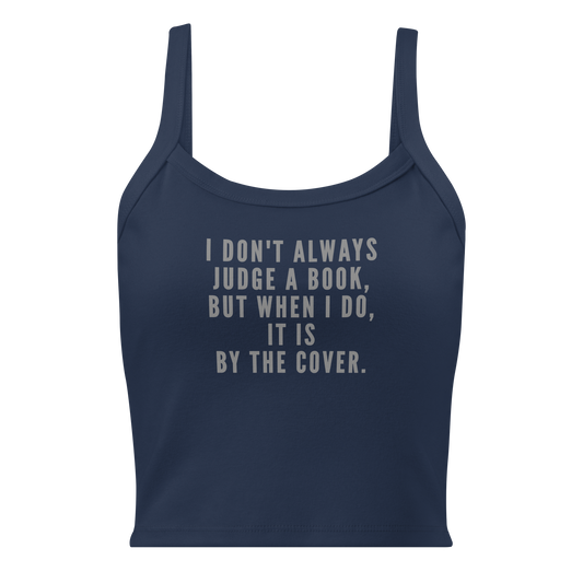 "I Don't always Judge a Book, but when I do, it's by the cover." printed on a solid navy blend women's micro-rib tanktop laying on a flat surface