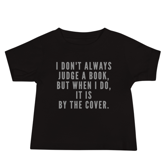 "I Don't always Judge a Book, but when I do, it's by the cover." printed on a black baby jersey short sleeve tee laying on a flat surface