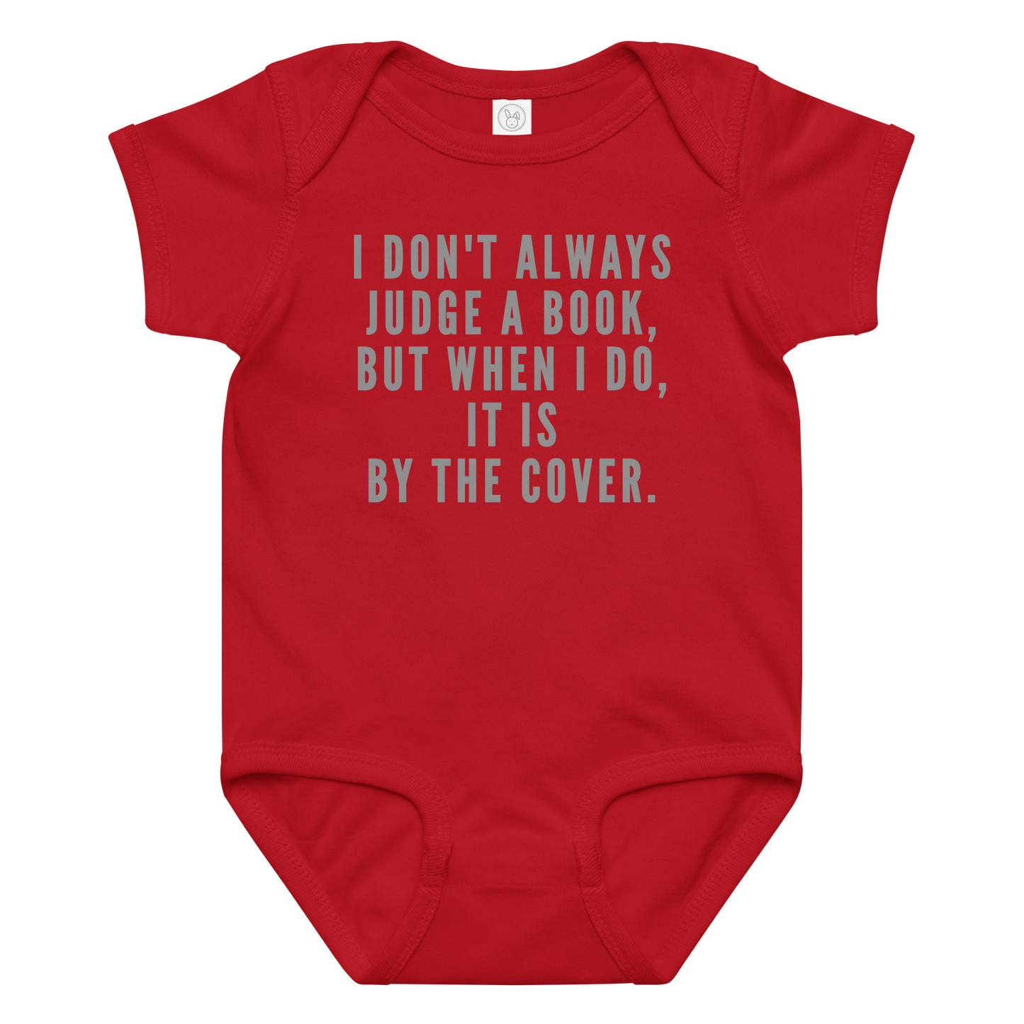 "I Don't always Judge a Book, but when I do, it's by the cover." printed on a red baby jersey bodysuit laying on a flat surface amongst other clothes