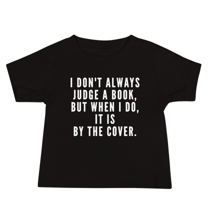 "I Don't always Judge a Book, but when I do, it's by the cover." printed on a black baby jersey short sleeve tee laying on a flat surface