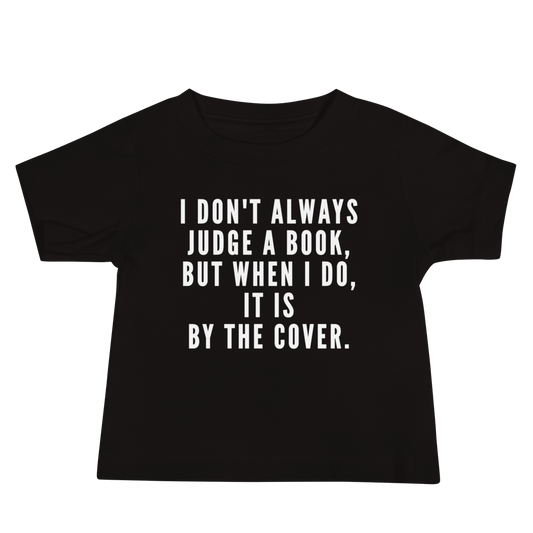 "I Don't always Judge a Book, but when I do, it's by the cover." printed on a black baby jersey short sleeve tee laying on a flat surface