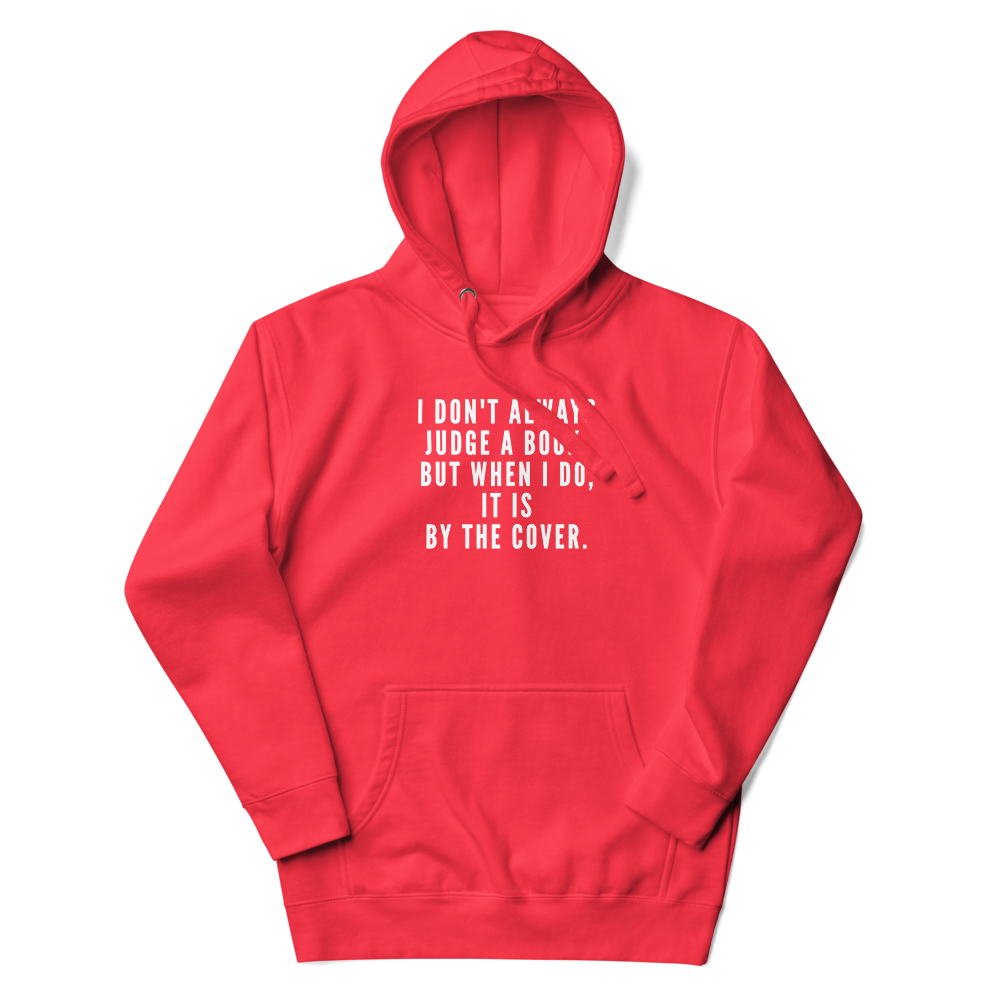 "I Don't always Judge a Book, but when I do, it's by the cover." printed on a team red unisex hoodie laying on a flat surface with the hood up