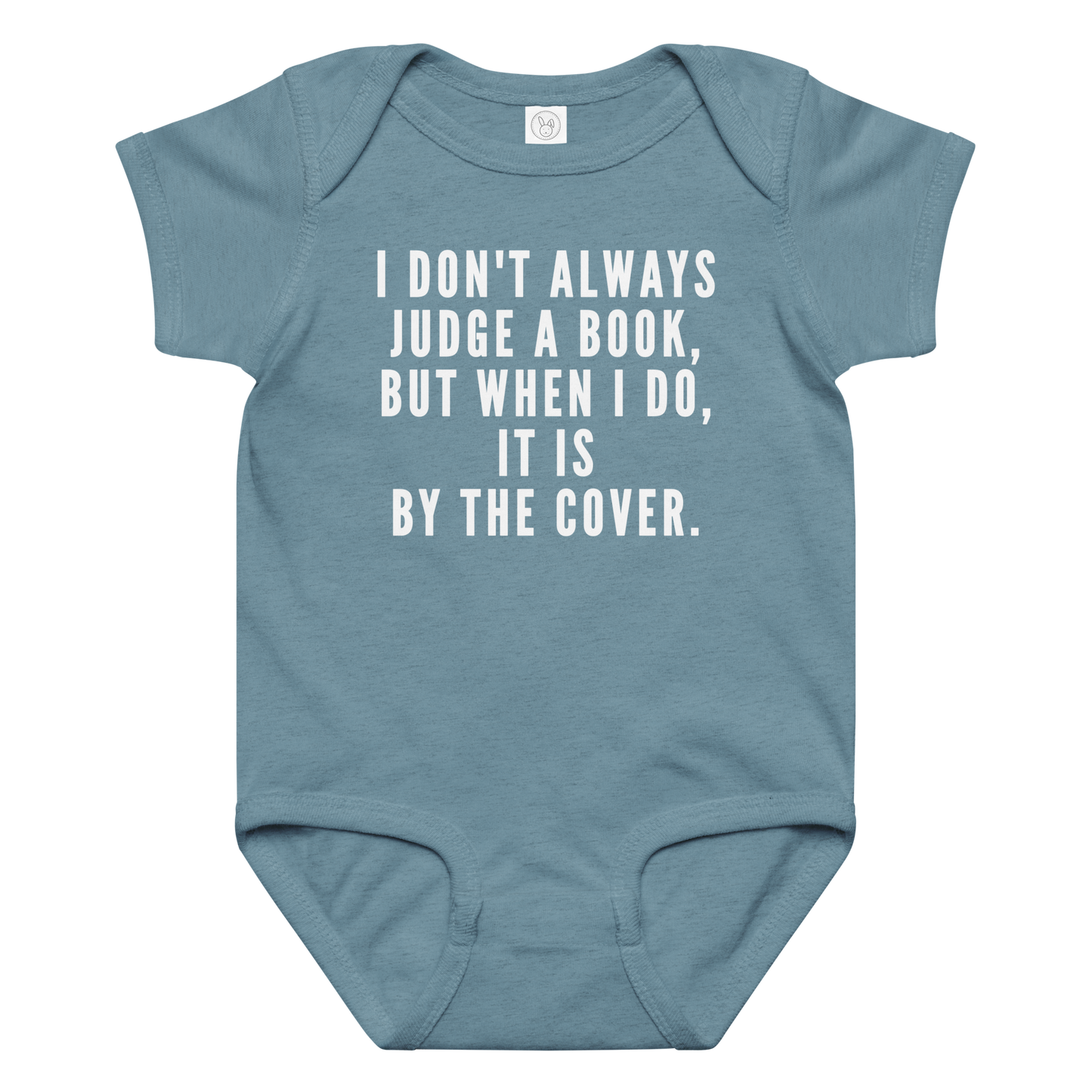 "I Don't always Judge a Book, but when I do, it's by the cover." printed on a vintage indigo baby jersey bodysuit laying on a flat surface amongst other clothes
